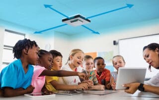 School children learning in a classroom with UV disinfection above them