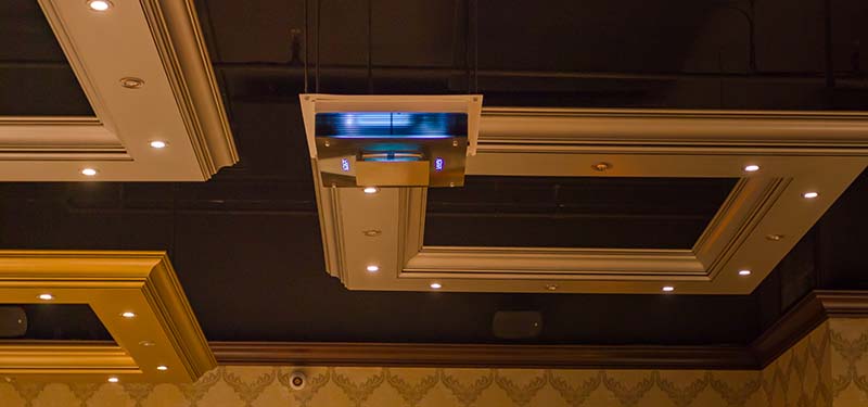 a square upper air UV unit is suspended from the ceiling of a restaurant