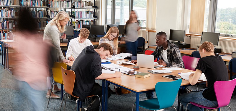 Teenagers studying in school library